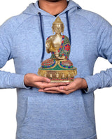 Hands holding 10-inch brass meditating Buddha statue, colorful inlaid robe