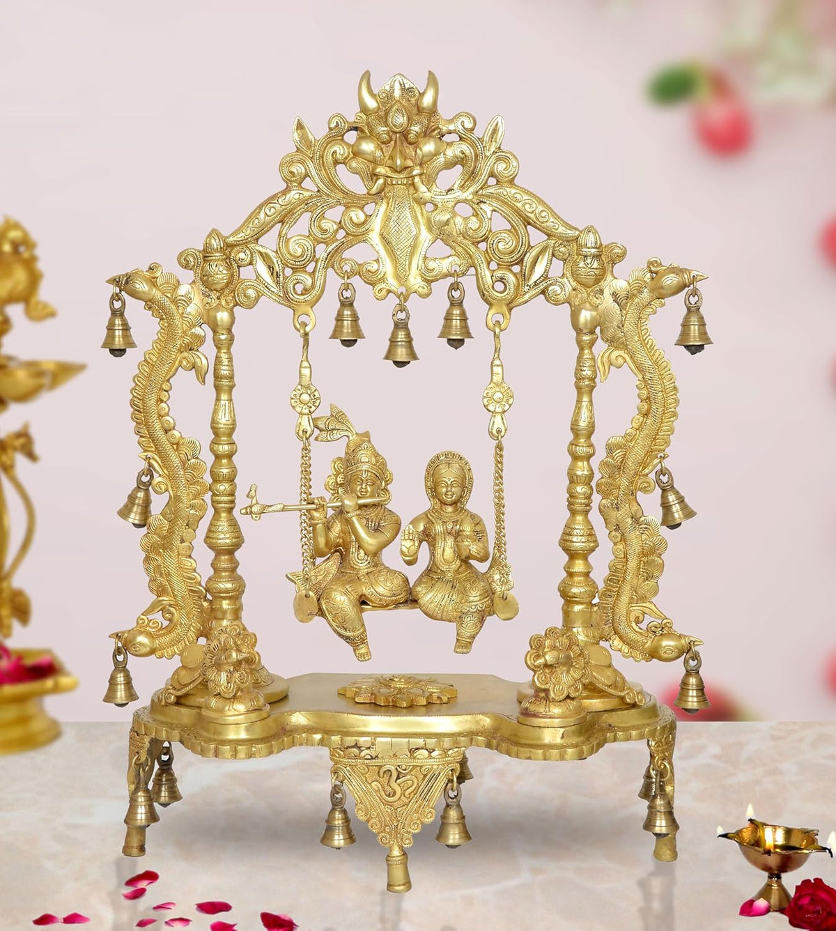 Golden brass Radha-Krishna swing idol statue with ornate frame and hanging bells