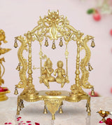 Golden brass Radha-Krishna swing idol statue with ornate frame and hanging bells