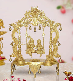 Golden brass Radha-Krishna swing idol statue with ornate frame and hanging bells