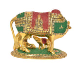 Gold cow statue with calf and Bal Krishna, green base with red cloth accents