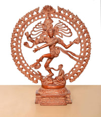 Lord Shiva dancing brass statue on pedestal, orange, framed by an ornate circular arch