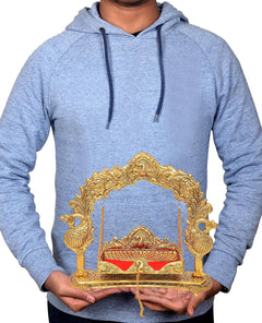 Laddu Gopal swing cradle shown being held: gold metal arch frame with red cushioned base