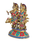 Krishna and Radha brass showpiece with small cow, colorful attire and ornaments