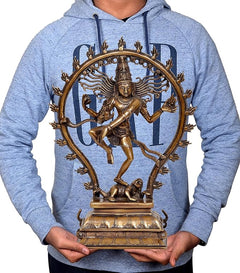 Brass Nataraj Lord Shiva idol held in hands, showing circular halo and dancing pose