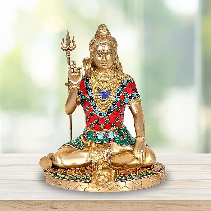 Brass Lord Shiva statue seated on lotus, holding trident; blue, red, green jeweled patterns