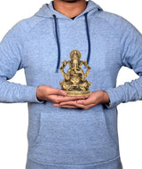 Gold-tone brass Ganesha idol held in hands, seated four-armed figure, ornate base