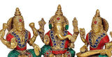 Brass Lakshmi Ganesh Saraswati statue close-up: gold faces with red eyes, raised hands