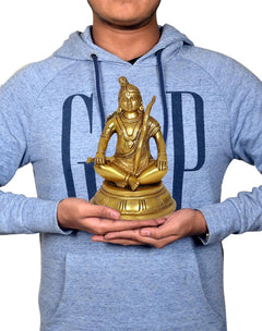 Gold-toned Ram Lalla brass sitting idol held in hands, 11 inch