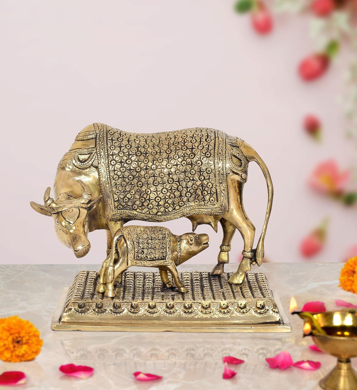 Brass cow with calf showpiece, ornate floral engraving, curved horns, on textured base