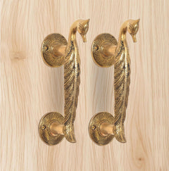 Golden brass peacock lever door handles with four round rosettes visible