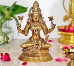 Brass Lakshmi statue on lotus with four arms, intricate gold-tone finish