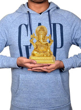 Man holding 7-inch brass Ganesha idol statue, seated figure on pedestal