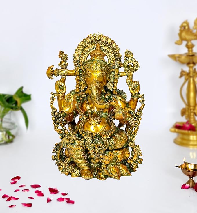 Brass Ganesha idol with ornate crown and four arms, seated on decorative base