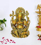 Brass Ganesha idol with ornate crown and four arms, seated on decorative base