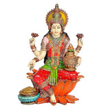 Lakshmi statue holding raised hands and pot, red saree with green accents, seated on lotus