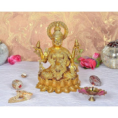 Brass Lakshmi idol seated with four arms, ornate crown halo and lotus base