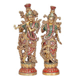 Radha-Krishna brass idol pair, standing poses with ornate crowns, painted details, pedestal base