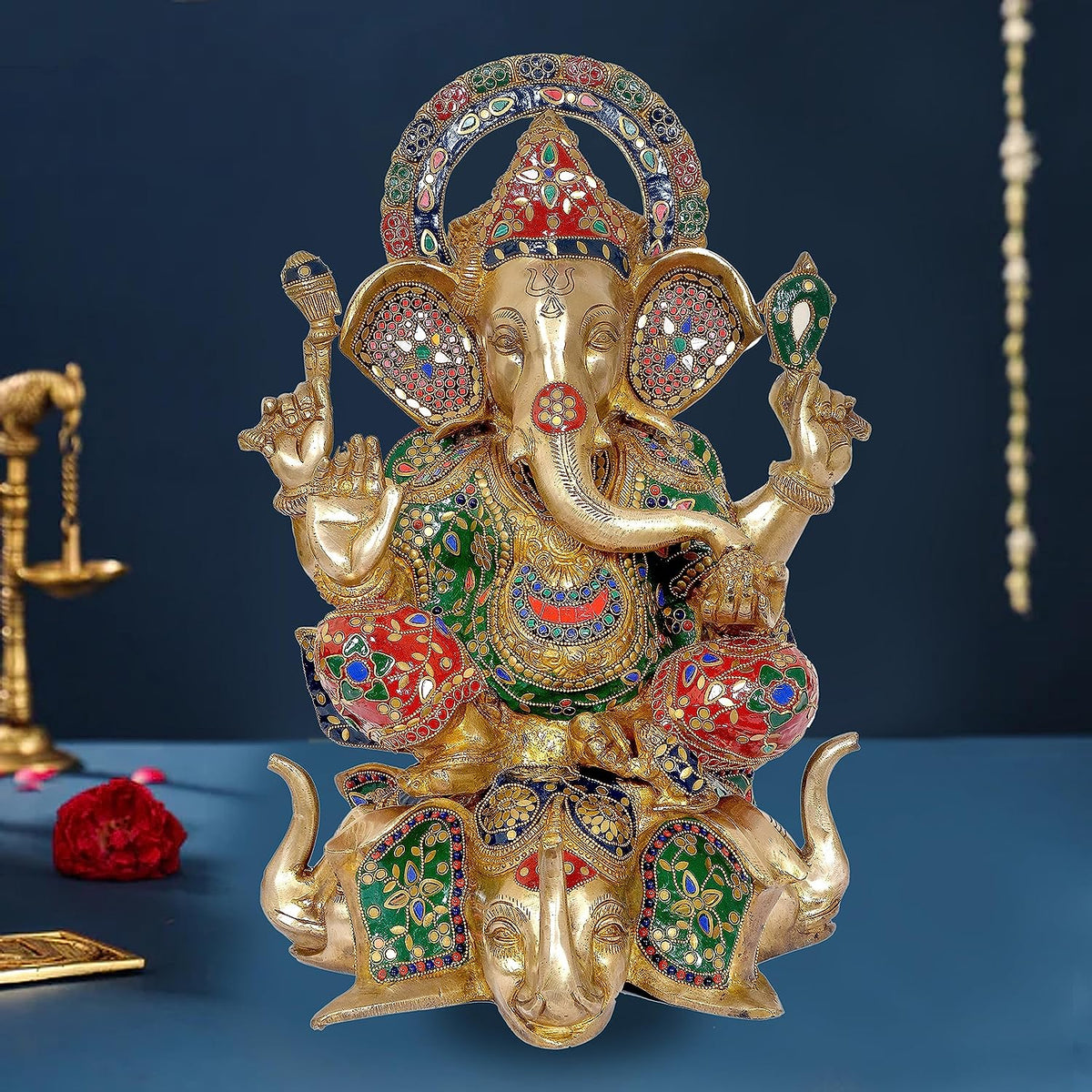 Brass Ganpati murti with multicolor temple detailing, seated on lotus, raised hands