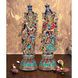 Brass Radha Krishna sculpture, two standing figures with teal, red and blue clothing