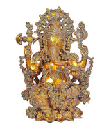 Brass Ganesha idol with intricate crown and four arms, seated front view