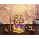 Brass Shiv-Parvati idol with trident, seated, multicolored robes, height 9.5 in
