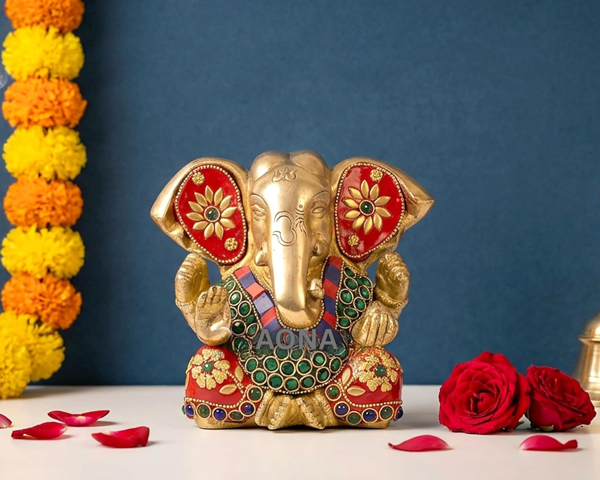Brass Ganesha idol with red gem-inlaid panels, gold trunk, seated