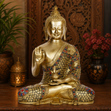 Brass Buddha statue in seated meditation, gold finish with red and blue inlay, raised blessing hand