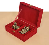 Red velvet gift box open at an angle with brass cow calf and Radha Krishna