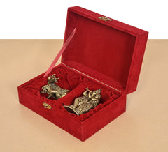 Red velvet gift box open at an angle with brass cow calf and Radha Krishna