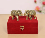 Brass elephant pair facing each other on red velvet-lined box