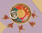 Handcrafted pooja thali plate with silver bowl on ornate round base, red-and-gold hanging details