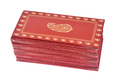 Red paper shagun envelopes with central ambi paisley design and gold corner accents.