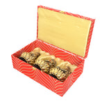Angled open Diwali puja box with three brass deities on lotus holders inside