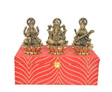 Brass Lakshmi, Ganesh, and Saraswati figures seated on lotus holders with red patterned box base