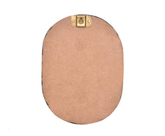 Back view of oval wooden plaque with two brass hanging hooks at the top
