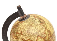 Beige world globe close-up on black ring with dial markings and mounted top knob