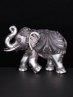 Silver brass elephant figurine with detailed engraved patterns, side view