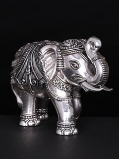 Silver brass elephant figurine, close-up front view with raised trunk and eye details