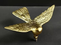 Brass eagle wall figurine angled view, wings spread with raised feather design
