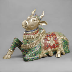 Seated brass Nandi sculpture with colorful floral stonework on body and harness