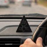 Ebony wood triangular Shiva trishul symbol sitting on a car dashboard