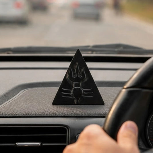 Ebony wood triangular Shiva trishul symbol sitting on a car dashboard