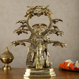 Brass Lord Shiva statue under tree, pedestal base with serpent trunk and raised trident