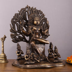 Brass Dakshinamurthy statue, seated pose with ornate halo and small seated figures