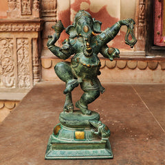 AONA brass dancing Ganesha idol with raised arms, ornate patina finish on pedestal base