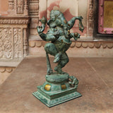 Brass Nritya Ganesha idol statue, rear three-quarter view with raised hands and crown