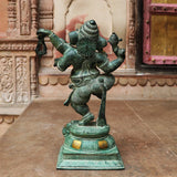 Back view of dancing Ganesha brass idol, ornate torso details and pedestal base with patina