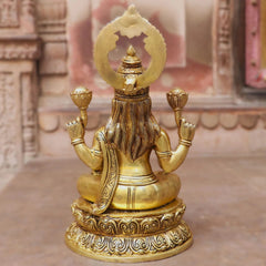 Back view of brass Lakshmi idol with raised hands and circular halo ornament