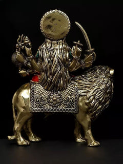 Back view of brass Durga statue on lion, lion mane texture and seated goddess figure